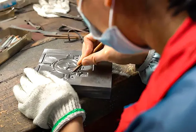 Skilled Artisan Engraving a Metal Mold by Hand